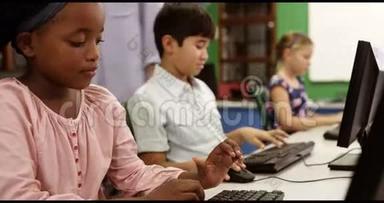 教师协助学童在教室使用个人电脑